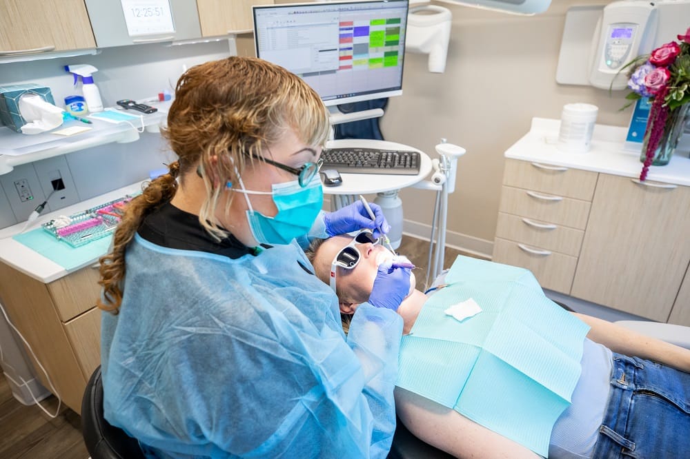 Dental Professional Performing Cosmetic Treatment – Cosmetic Dentist Kirkland Dentist in protective gear working on a patient's smile during a cosmetic procedure, showcasing advanced dental care – Cosmetic Dentist Kirkland