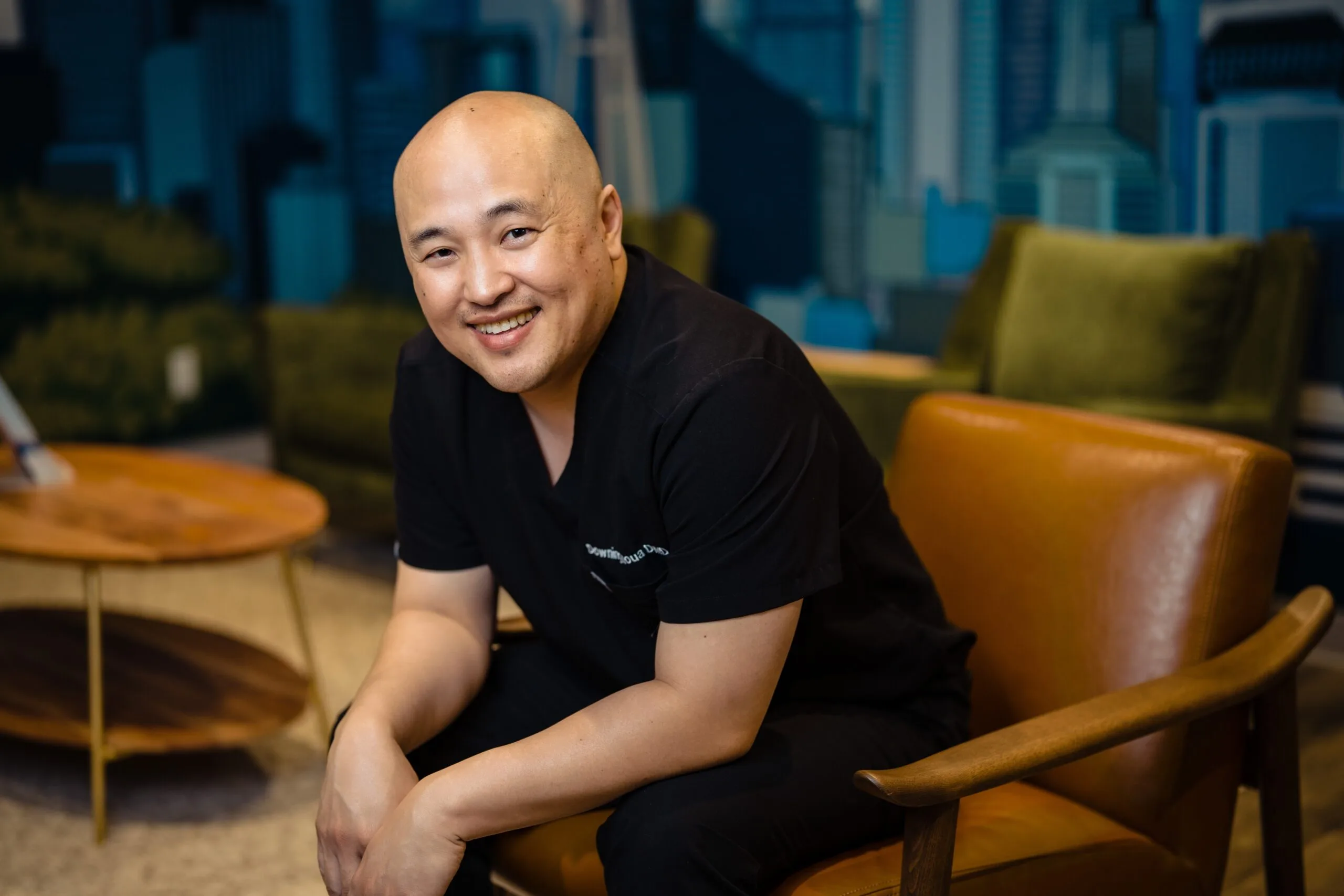 Dr. Downing Moua Smiling at Kirkland Dental Office – Kirkland Dental Portrait of Dr. Downing Moua seated and smiling in a modern Kirkland Dental office setting – Kirkland Dental