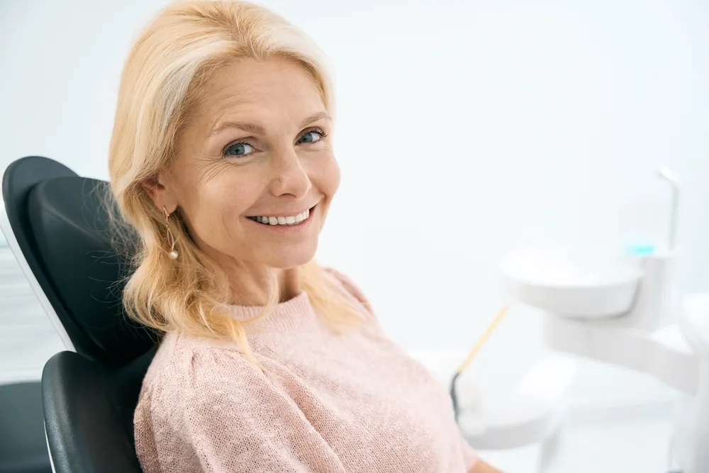 Happy Mature Patient at Kirkland Dental Clinic – Kirkland Dental Smiling older woman seated in a dental chair during her visit at Kirkland Dental clinic – Kirkland Dental